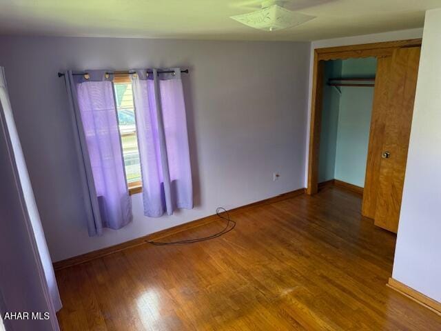 empty room featuring wood finished floors and baseboards