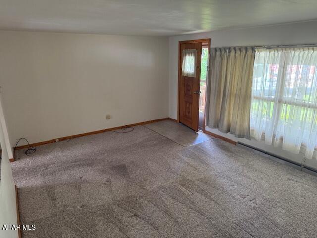 unfurnished room featuring light carpet and baseboards
