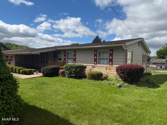 view of front of house featuring a front lawn and stone siding