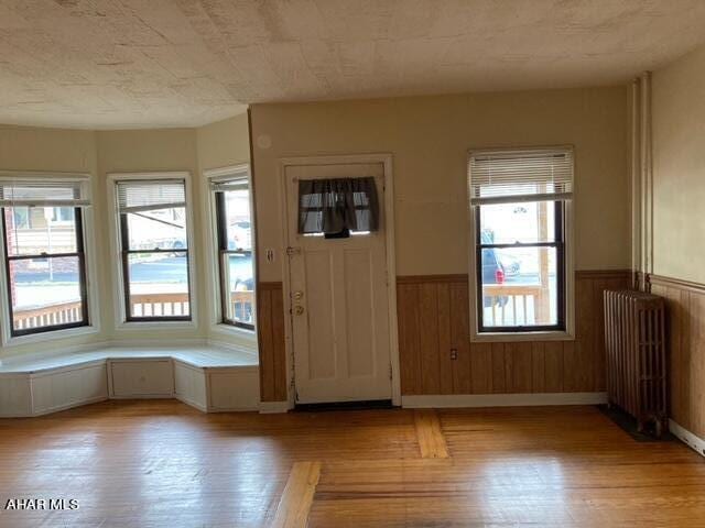 entryway with a wealth of natural light, radiator heating unit, and light hardwood / wood-style flooring