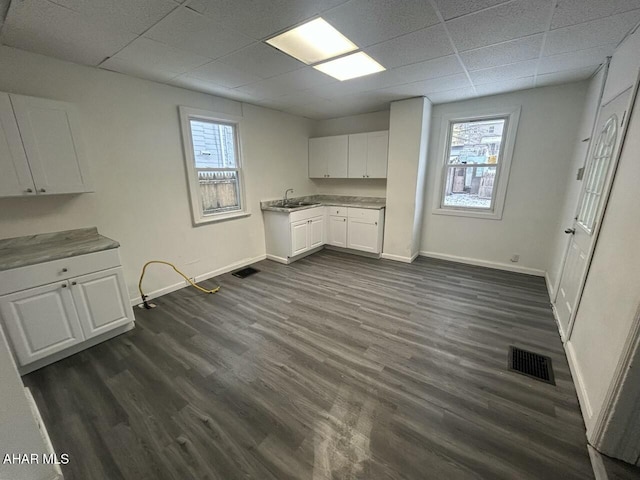 kitchen featuring a drop ceiling, dark hardwood / wood-style floors, sink, and white cabinets