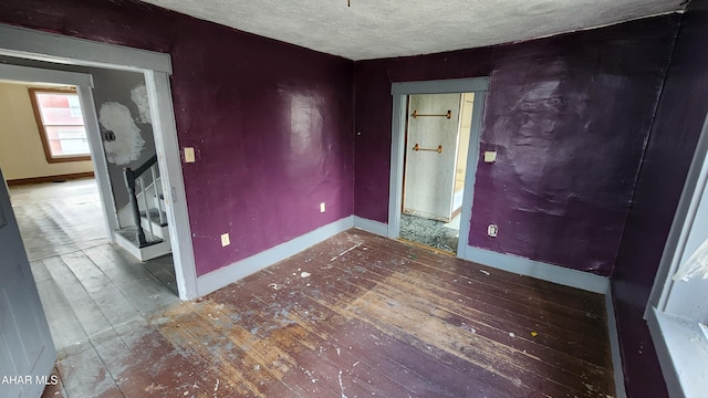 empty room with hardwood / wood-style flooring and a textured ceiling