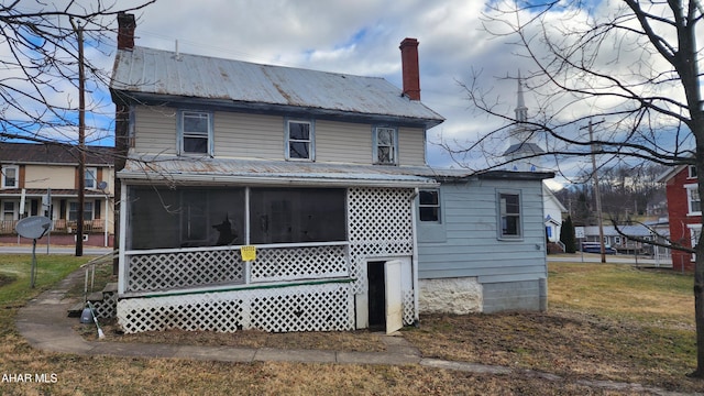 rear view of property with a sunroom