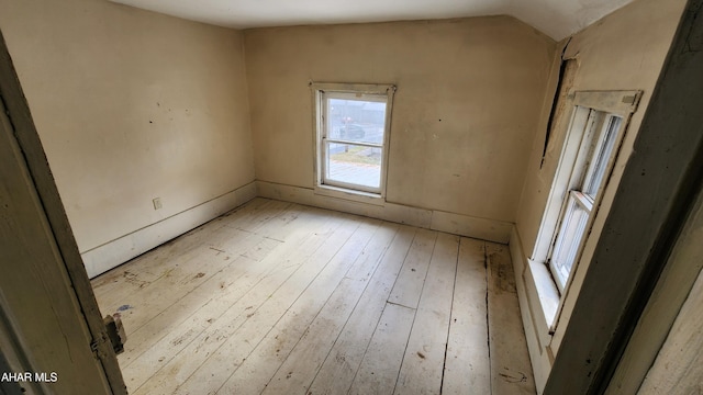 unfurnished room with lofted ceiling and light hardwood / wood-style flooring