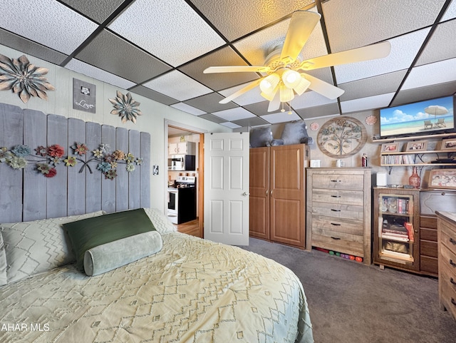 carpeted bedroom featuring a paneled ceiling and a ceiling fan