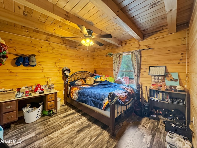 bedroom with beam ceiling, ceiling fan, wood walls, and hardwood / wood-style floors