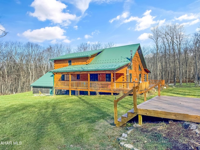 rear view of house featuring a yard and a wooden deck