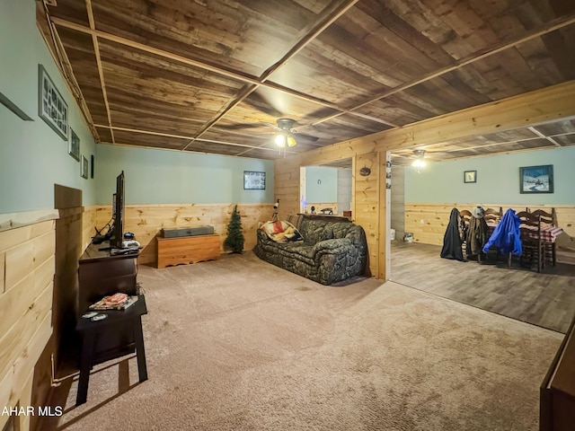 interior space featuring carpet flooring, wood walls, and wood ceiling