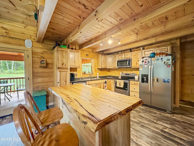 kitchen featuring appliances with stainless steel finishes, light hardwood / wood-style floors, wooden walls, and beam ceiling