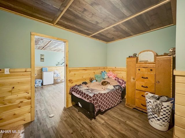 bedroom with wood ceiling, wood-type flooring, ornamental molding, and wooden walls