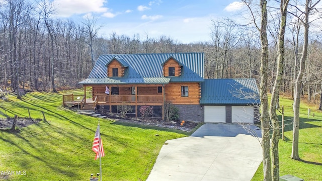 cabin with covered porch, a garage, and a front yard