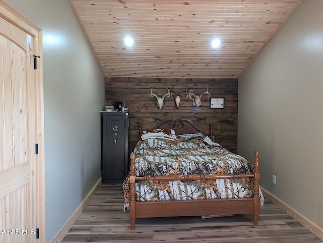 bedroom with hardwood / wood-style floors, vaulted ceiling, wooden walls, and wood ceiling