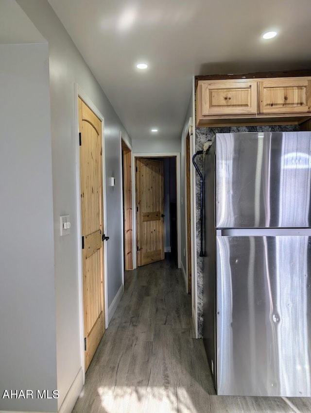 kitchen with light brown cabinets, dark hardwood / wood-style flooring, and stainless steel refrigerator