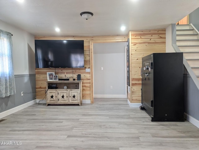 living room featuring wooden walls and light hardwood / wood-style floors