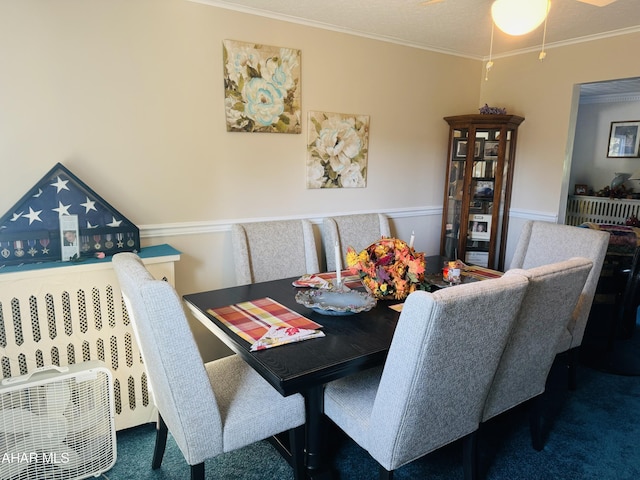 dining space with dark colored carpet, ceiling fan, and ornamental molding