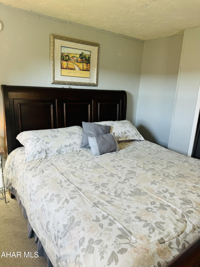 bedroom featuring carpet flooring and a textured ceiling