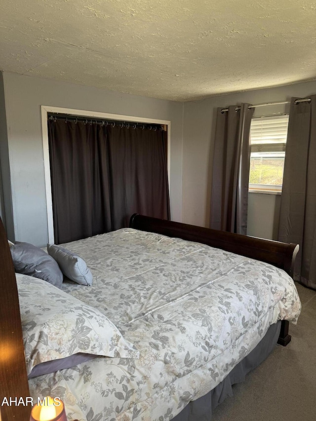 bedroom with carpet floors, a textured ceiling, and a closet