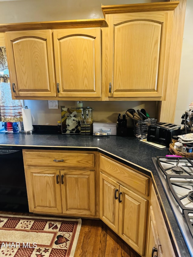 kitchen featuring stainless steel gas stovetop, black dishwasher, and dark wood-type flooring