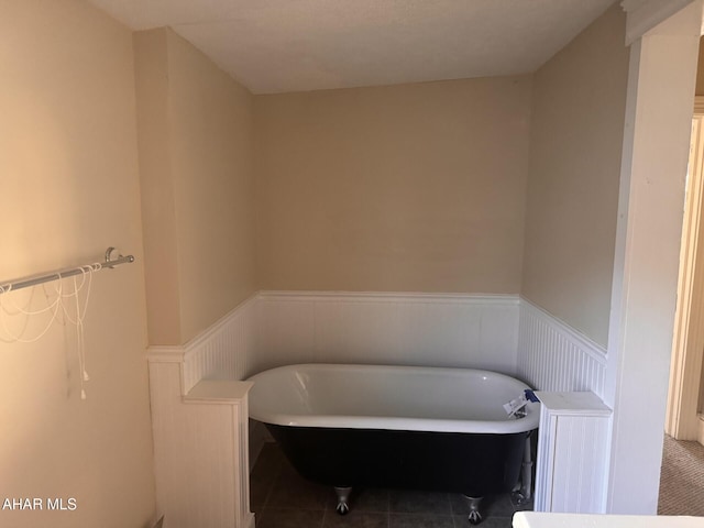 bathroom with tile patterned floors and a bath