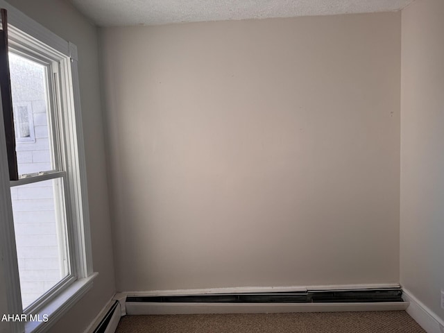 carpeted empty room with a textured ceiling