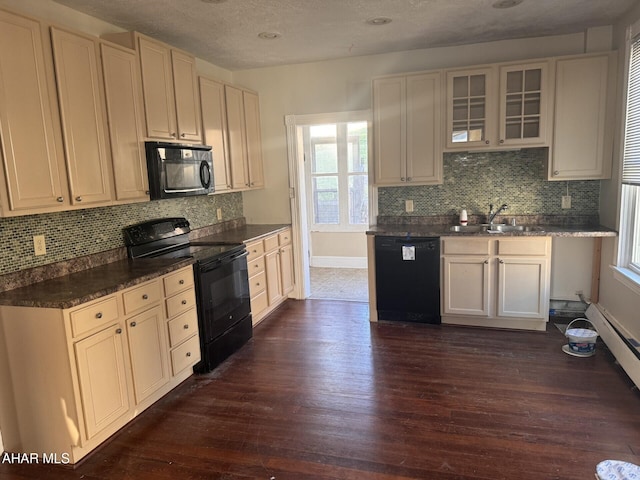 kitchen with dark wood-type flooring, black appliances, sink, decorative backsplash, and a textured ceiling