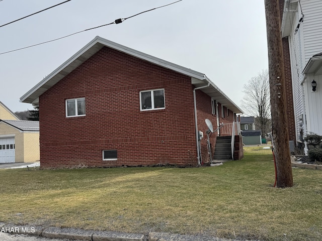 view of side of home with brick siding and a yard