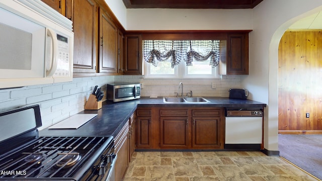 2513 Quail Ave, Altoona, PA 16602 - kitchen featuring appliances with stainless steel finishes, dark countertops, arched walkways, decorative backsplash, and light stone finish flooring