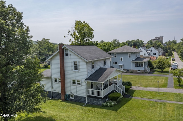2513 Quail Ave, Altoona, PA 16602 - back of property with a chimney, a lawn, a shingled roof, and covered porch