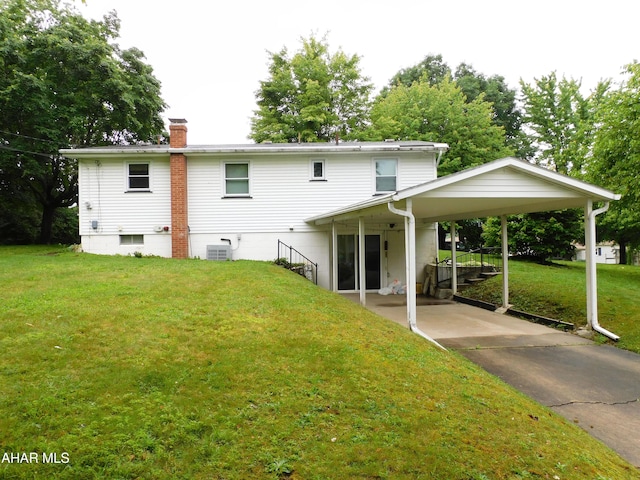 315-323 E 23rd Ave, Altoona, PA 16601 - back of property featuring a lawn, a chimney, an attached carport, and driveway