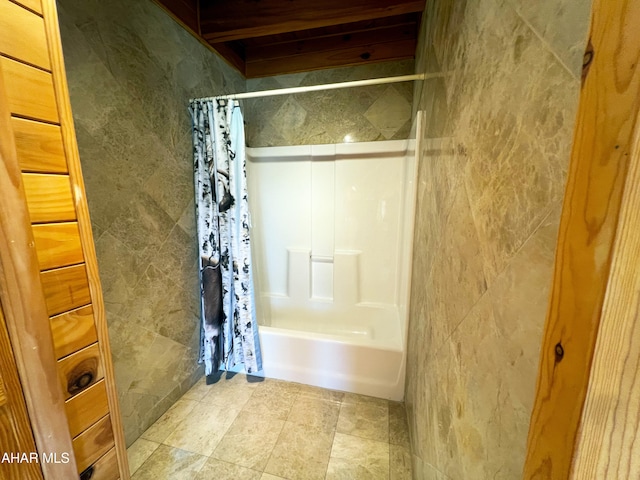 bathroom with shower / bath combination with curtain and tile walls