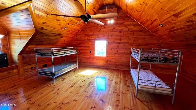 unfurnished bedroom featuring wood ceiling, wooden walls, vaulted ceiling, and hardwood / wood-style flooring