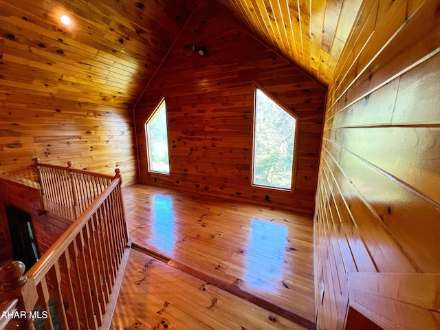 additional living space with wood-type flooring, wood ceiling, vaulted ceiling, and a healthy amount of sunlight