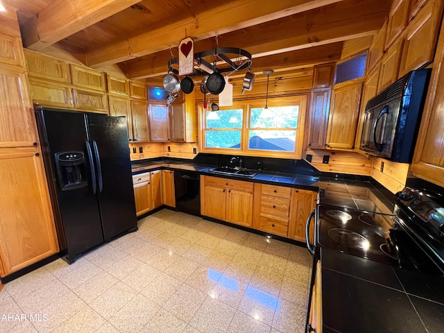 kitchen with sink, black appliances, and beamed ceiling