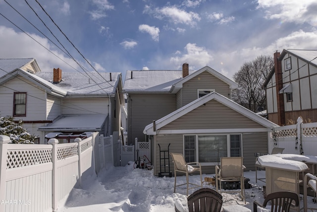 view of snow covered rear of property