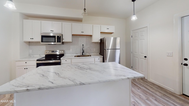 2602 W Chestnut Ave, Altoona, PA 16601 - kitchen featuring appliances with stainless steel finishes, decorative backsplash, light wood finished floors, a center island, and white cabinetry