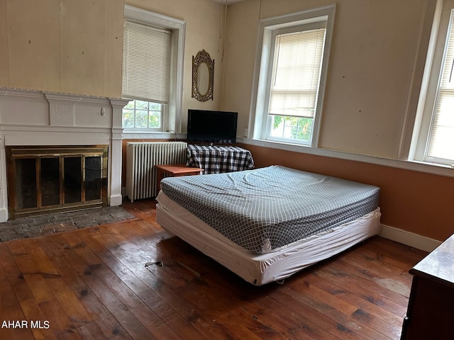 bedroom featuring dark hardwood / wood-style flooring and radiator heating unit