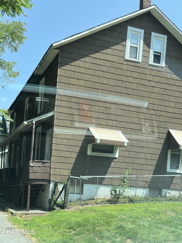 view of side of home with a yard