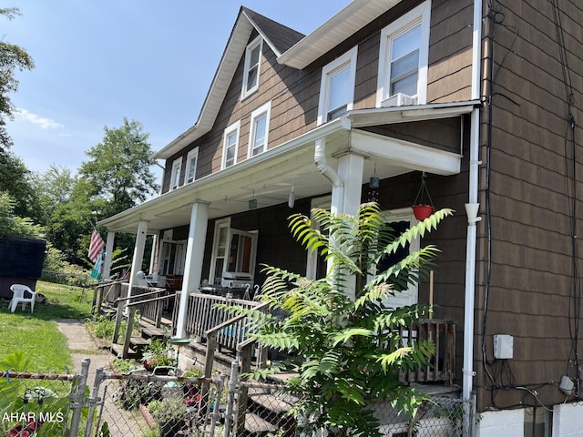 view of side of home featuring covered porch