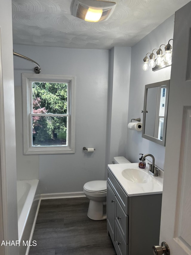 bathroom with hardwood / wood-style floors, vanity, a textured ceiling, and toilet