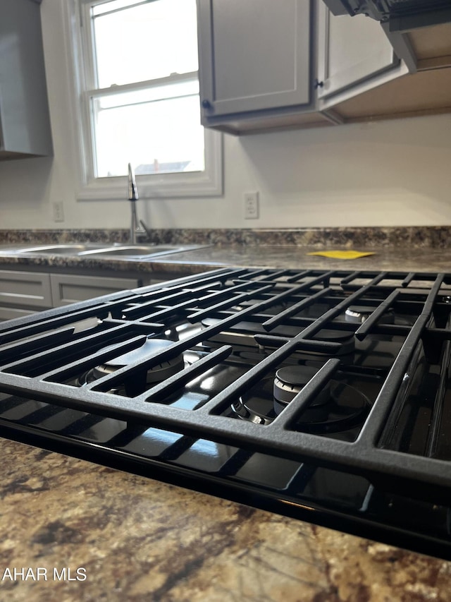 interior details featuring gray cabinetry, sink, and gas cooktop