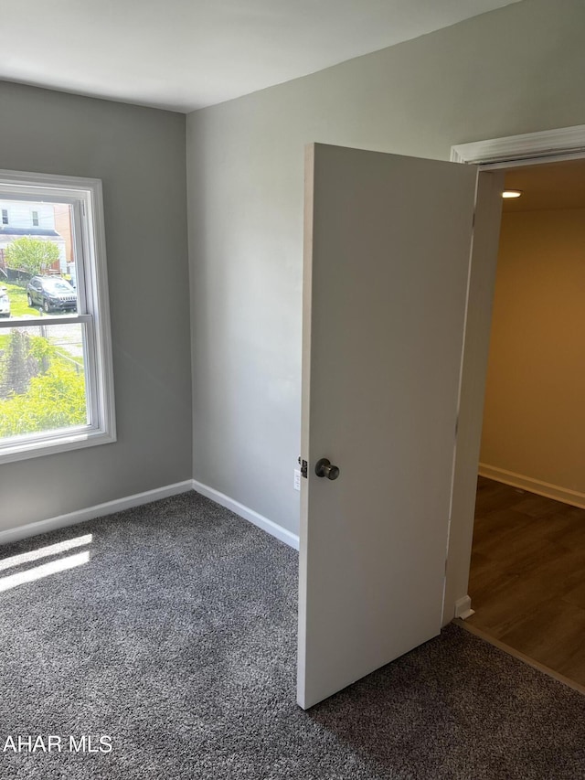 empty room featuring dark carpet