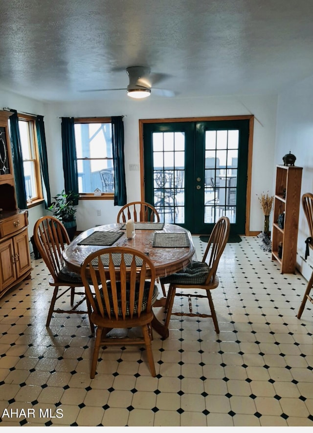 dining space with french doors and a textured ceiling