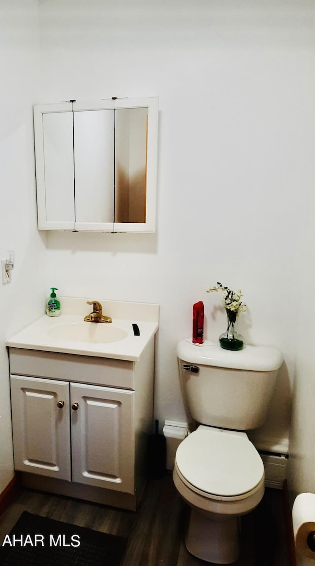 bathroom featuring vanity, hardwood / wood-style flooring, and toilet