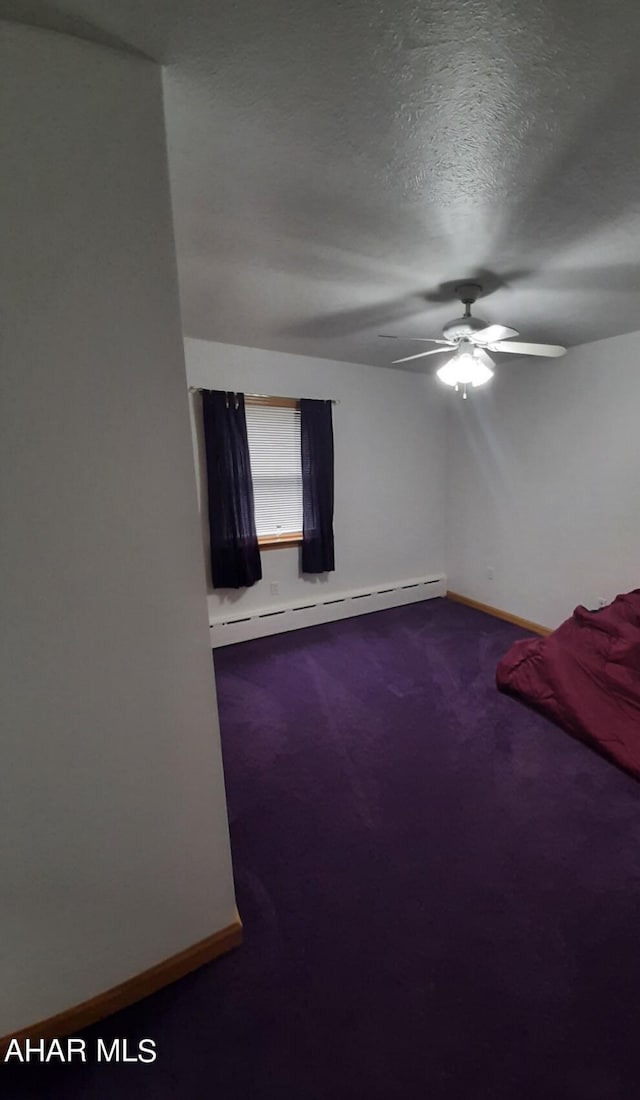 spare room featuring a textured ceiling, ceiling fan, carpet floors, and baseboard heating