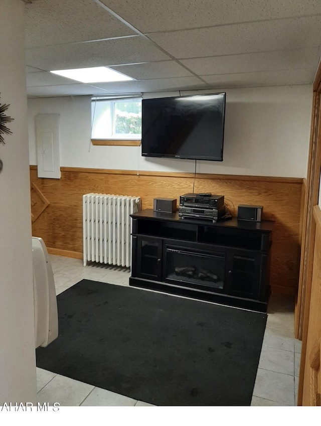 interior space with wooden walls, light tile patterned flooring, and radiator