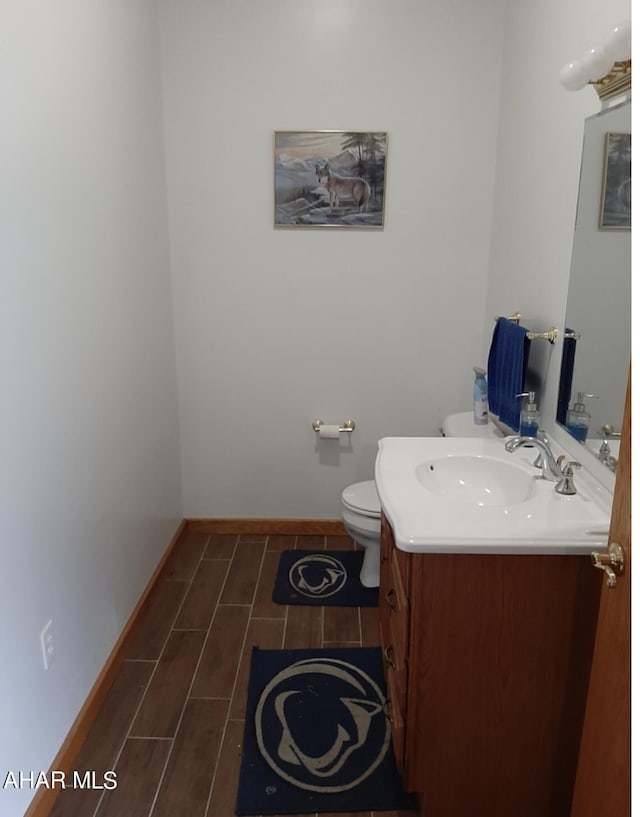 bathroom featuring hardwood / wood-style floors, vanity, and toilet