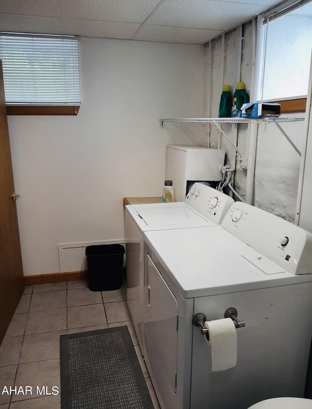 laundry room with a wealth of natural light, independent washer and dryer, and light tile patterned floors