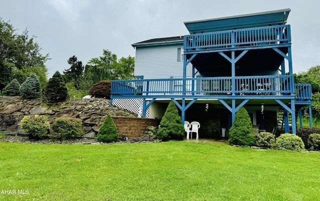 back of property featuring a deck and a lawn