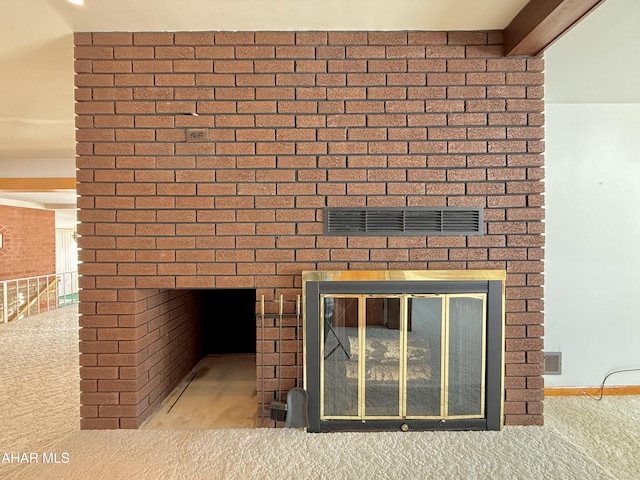 room details featuring a brick fireplace and beamed ceiling