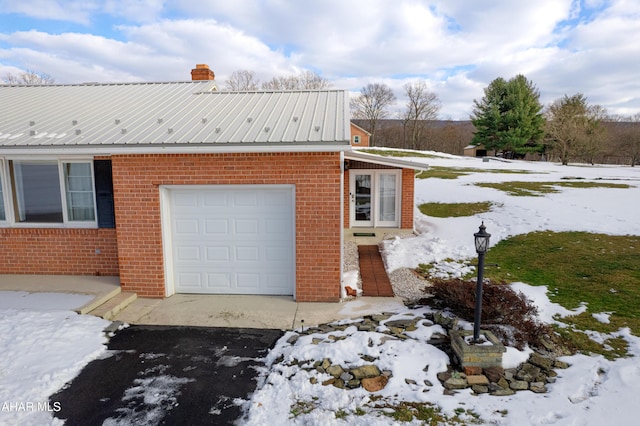 view of snow covered exterior with a garage